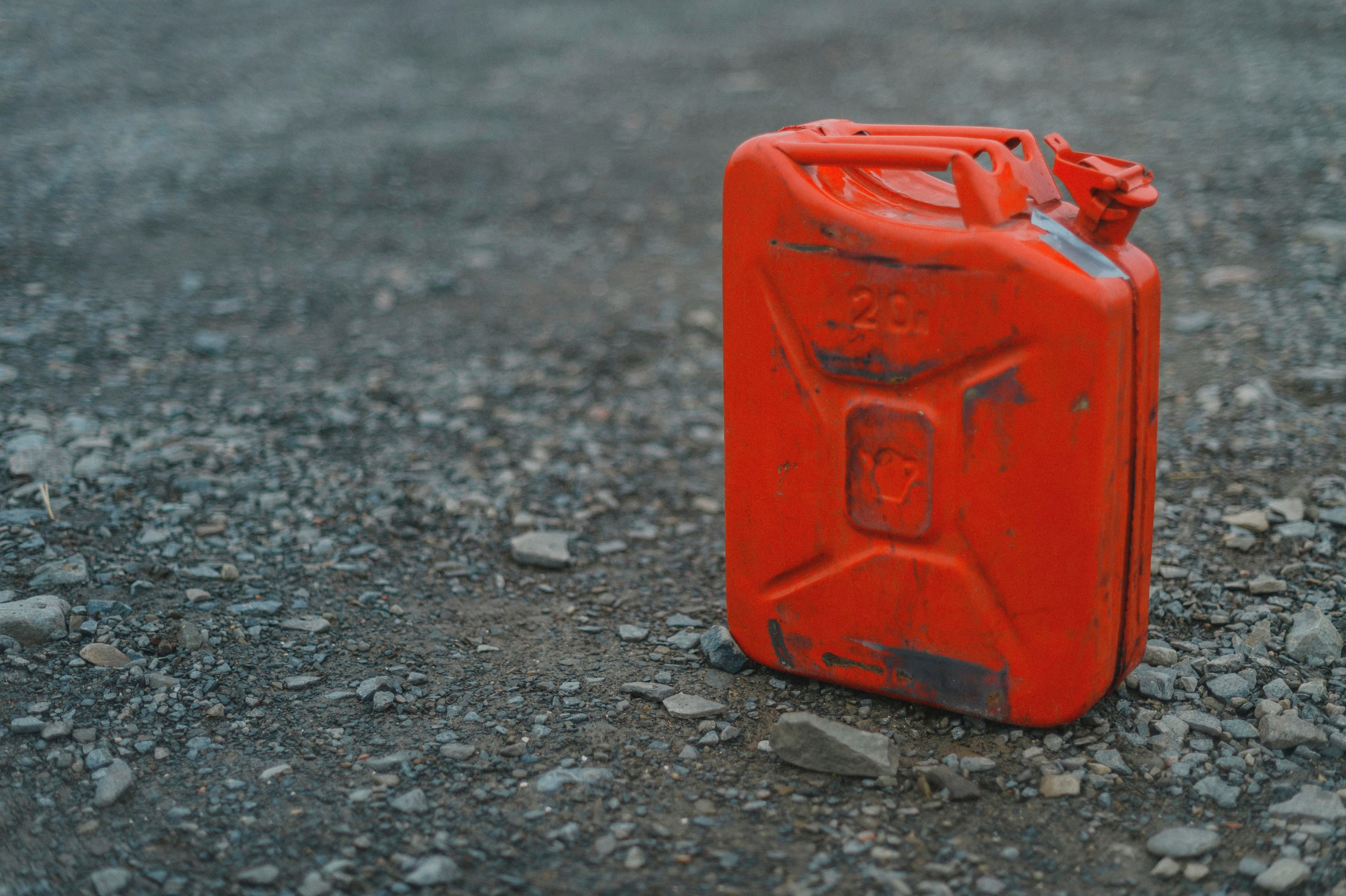 Red jerry can standing on gravel