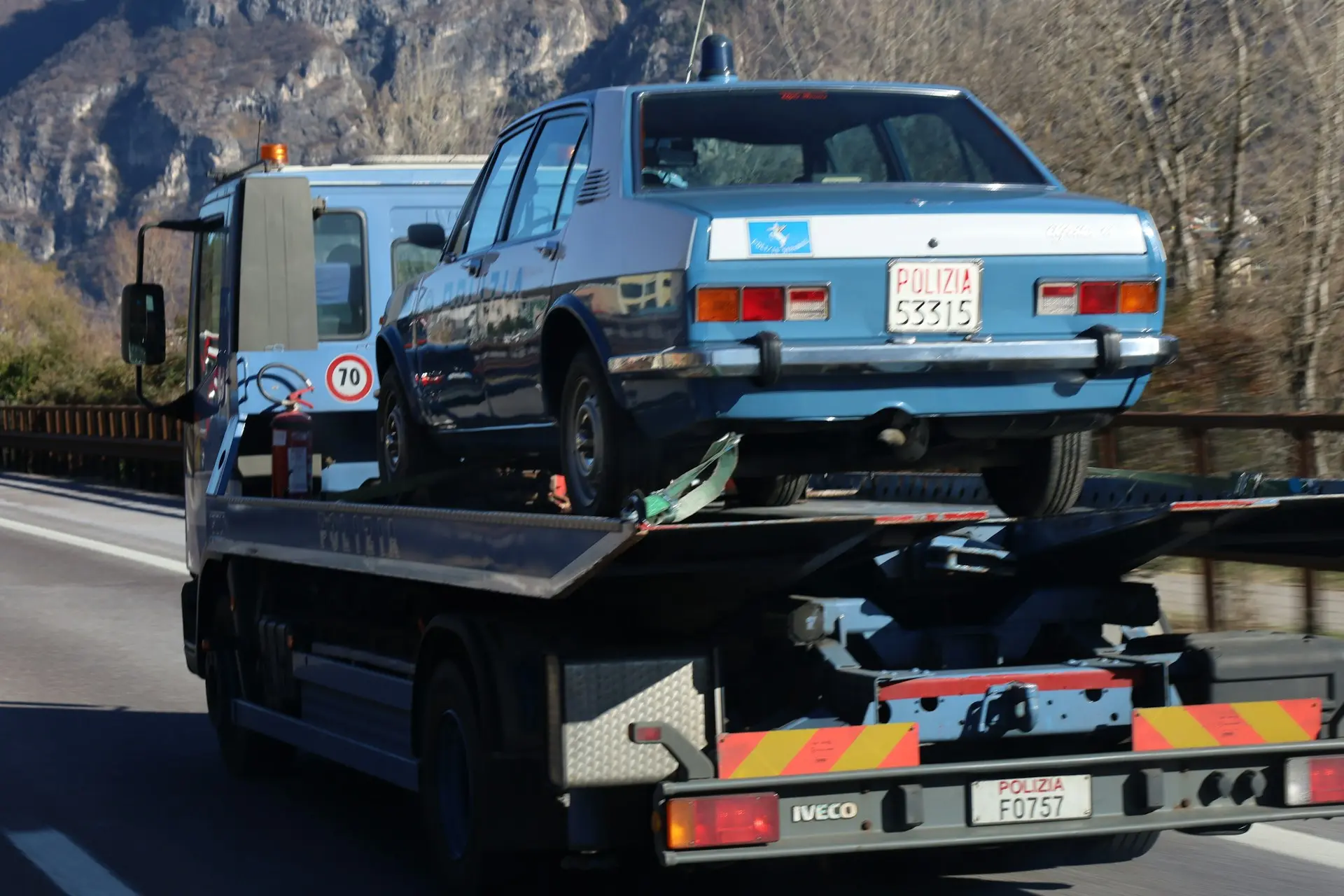 Car strapped onto the back of a flatbed recovery truck on the motorway